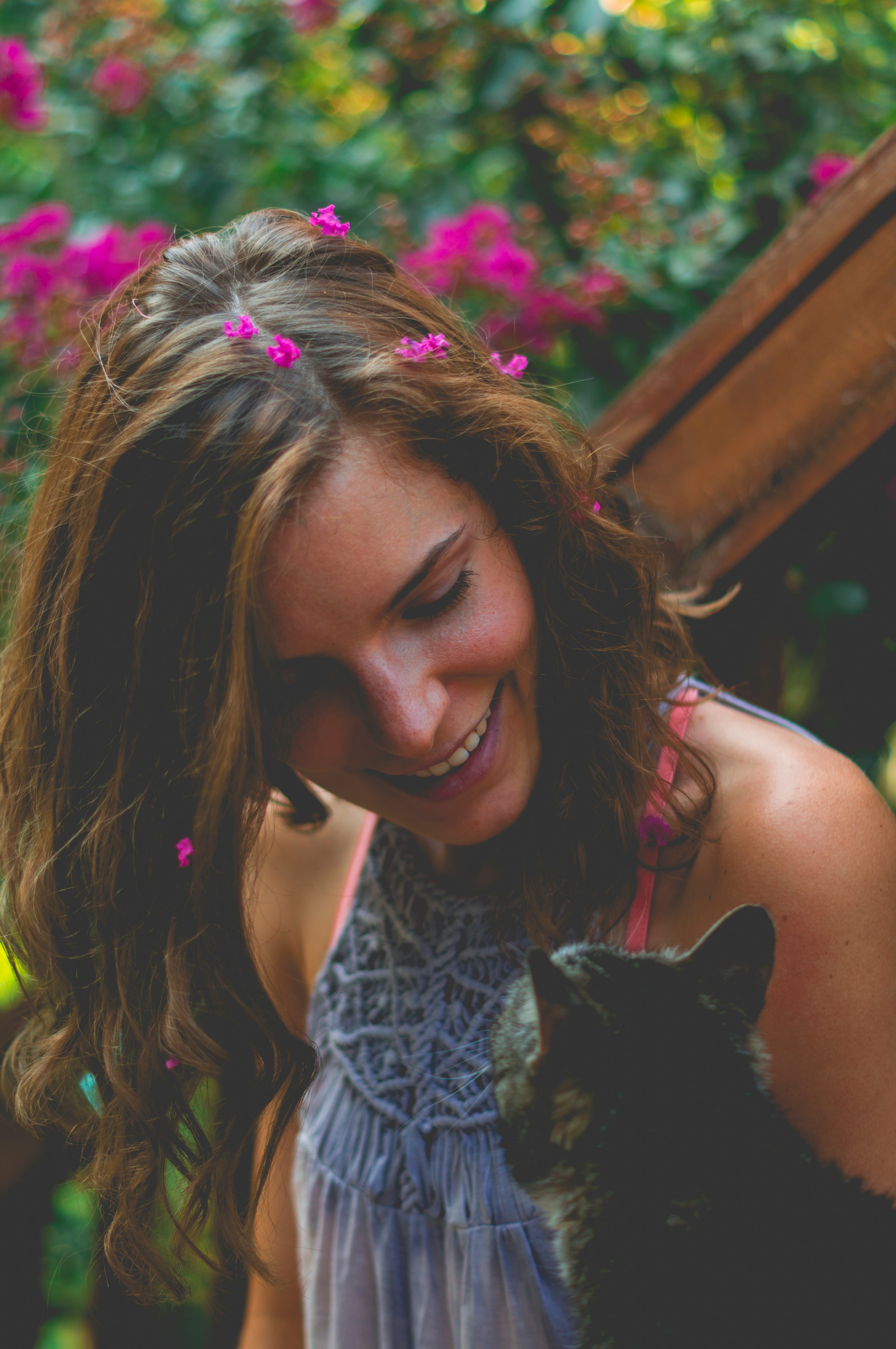 smiling woman looking at brown tabby cat